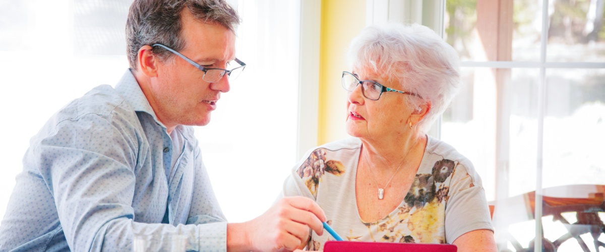 A man counseling an elder about Health Insurance